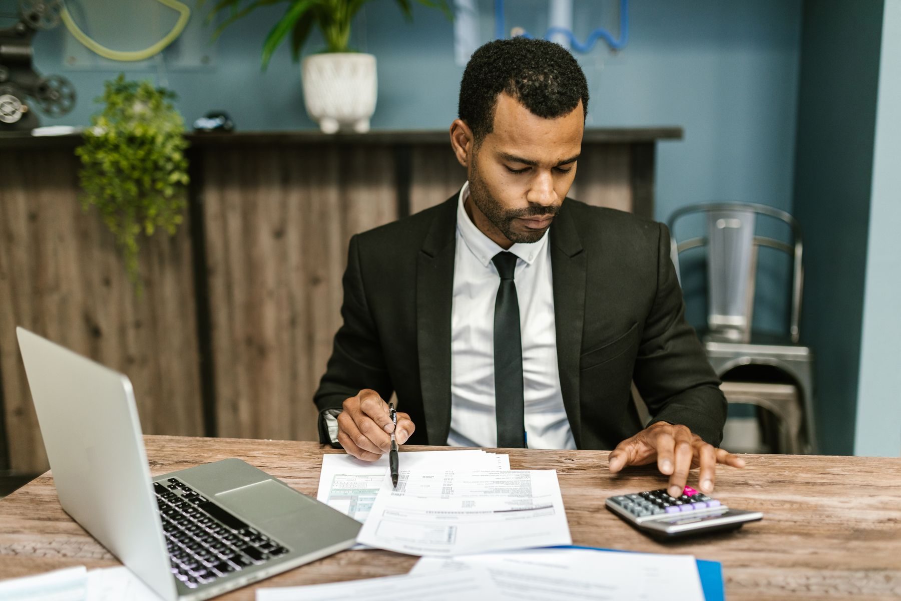 An accountant working through a client&rsquo;s paperwork at his desk