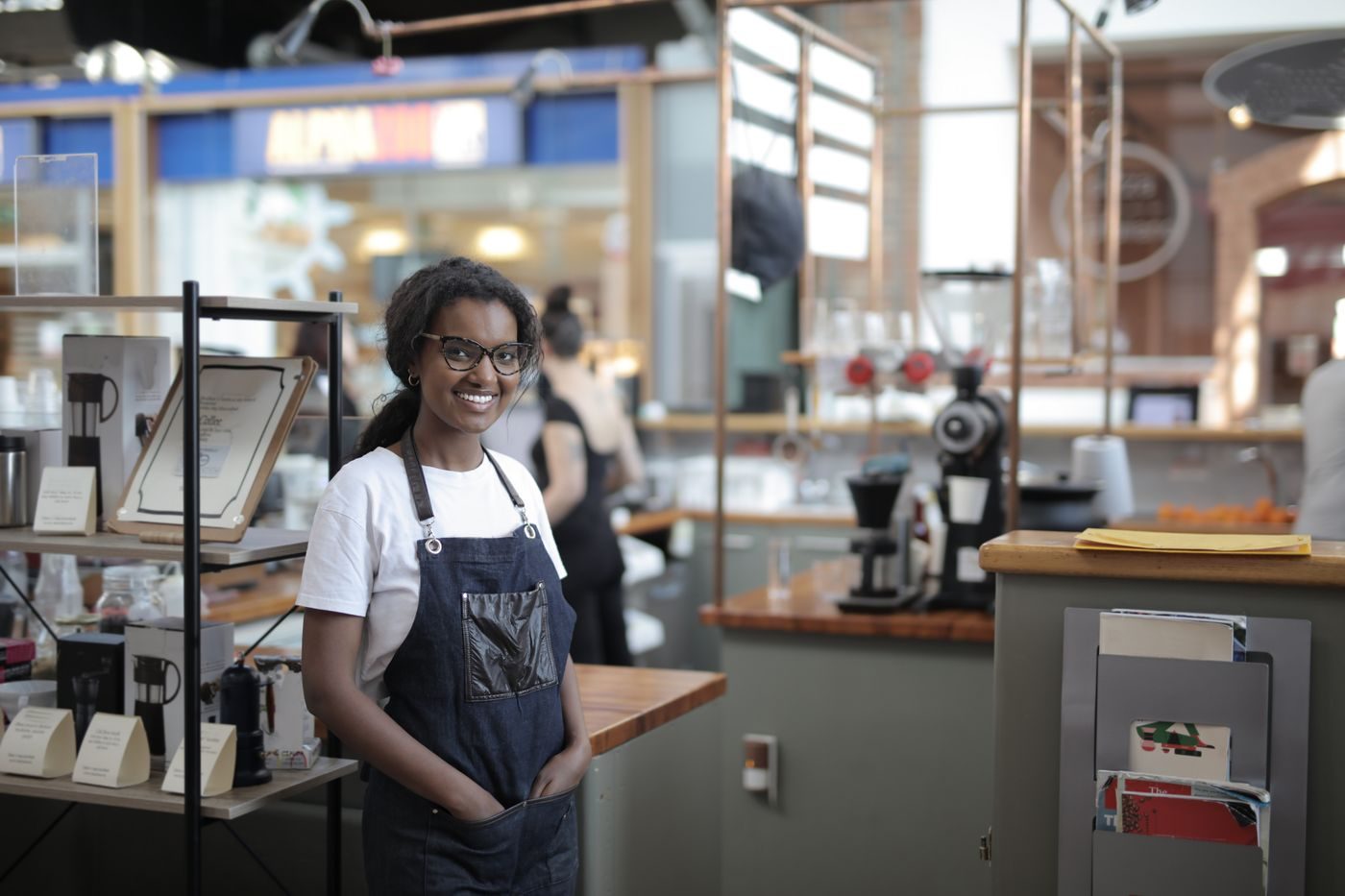 A caf&eacute; owner standing behind her counter